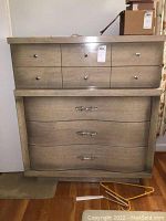 Front view of the vintage Harmony House dresser showing six small drawers on top and three large curved drawers below in light brown wood with metal hardware.