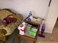 Swiffer Wet Jet mop, refills boxes, cleaning bottles on side tables near couch