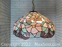 View of the Tiffany style hanging lamp showing floral stained glass design and hanging chain.