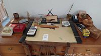 Wooden desk with multiple office items including Canon TP-7 calculator, Parker pen/pencil set, leather desk organizer, and other accessories