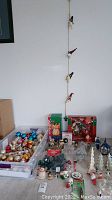 Overview of lot contents: storage bin of ornaments, ceramic figurines, trees, lanterns