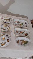 Nine pieces including lids Evesham Cookware with fruit and vegetable designs; largest platter 17x10.5 inches