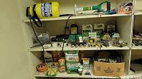 Shelf with various gardening products including fertilizers, sprays, and hose connectors.
