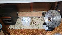 Lot with three heaters and a patterned area rug on the floor.