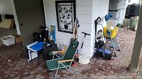 Wide shot showing the full lot including chairs, pressure washer, cleaning tools, step ladder, metal wall art.