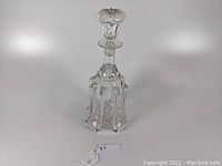 Full view of the blown glass decanter with stopper on top, showing overall shape and design.