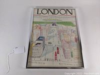 Full view of a framed London illustrated poster with visible city streets and colored buildings