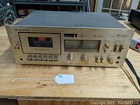 Front view of Kenwood KX-1030 cassette deck showing cassette window, control buttons, power switch and knobs.