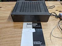 Amplifier on wooden table with manual in front