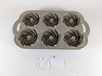 Top-down view of the Nordic Ware Heritage Bundtlette pan showing 6 swirl bundtlette molds and side handles.