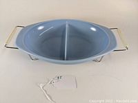 Oval divided vegetable serving bowl in Delphite blue color with original wire caddy and cream handles.