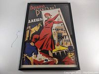 Full view of framed propaganda poster showing woman in red dress and Cyrillic slogan