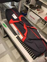 Closed carry bag with red handles, labeled for carrying the camping bed.