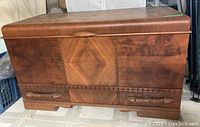 Front view of the vintage wood chest showing inlay wood and two lower drawers with wooden handles, highlighting the wood bead detailing between drawers.