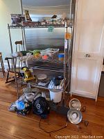 Overall shelving unit with assorted home improvement and cleaning items arranged on and around it