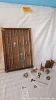 Full view of solid wood shadow box with multiple compartments and several brass miniatures inside, plus separate wood miniature items beside it