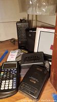 Overview of all included electronics: Nook with case, two Texas Instruments calculators, GPX cassette player, Sony Walkman, Bose earbuds, Sony AM/FM receiver.