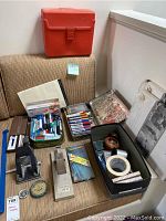 Full lot of office supplies items arranged on a beige fabric surface including folders, notebooks, markers, tape, and other small office tools.