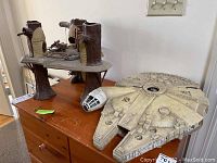 Millennium Falcon and Playskool treehouse on wooden cabinet, side view