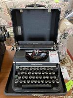 Front view of Underwood Universal typewriter inside open carry case showing keys and brand name on front panel.