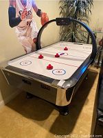 Three-quarter angle view of entire air hockey table in room setting