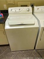 Front view of white Maytag Atlantic top load washer showing control panel and closed lid