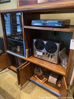Wooden cabinet with audio components including turntable, reel-to-reel deck, equalizer and cassette deck