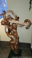 Front angled view of the wooden sculpture showing twisting branches and natural wood textures.