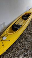 Full left-side view of yellow canoe showing two bench seats and deck rigging