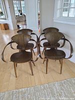 Four matching modern wood chairs grouped in living area