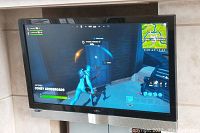 TV powered on displaying a video game, showing screen functionality and size.