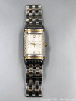 Full front view of the Bulova women's watch showing the rectangular face with diamond-set bezel and stainless steel bracelet with gold plating accents.