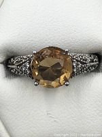 Close-up photo of the citrine gemstone and ornate sterling silver band showing detailed craftsmanship and prong settings.