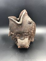 Front view showing fish head with open mouth as vase opening and textured scales