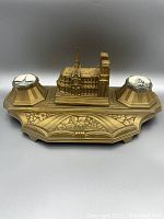 Front view of metal inkwell showing Notre-Dame replica and ink pots