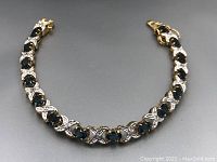 Full view of bracelet laid in curve on gray background