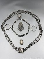 Full lot of six sterling silver and gold jewellery pieces laid out, showing necklace, ladybug pendant, brooch, bracelet, and rings.