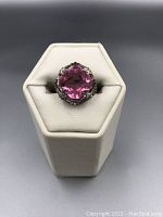 Front view of ring showing large cushion-cut pink topaz in detailed sterling silver mount.