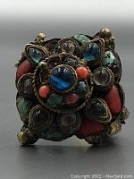 Close-up front view showing the mixed semi-precious stones in blue, turquoise, coral, and purple set in metal base.