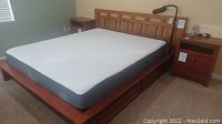 Assembled bed frame with mattress on top, showing overall size, headboard, footboard, and drawers