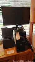 Photo showing black HP Pavilion PG2378 desktop tower, Samsung monitor on top, black wired mouse, and two black speakers on the left side.