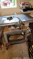 Overview of table saw mounted on rolling platform in garage setting
