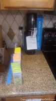 SodaStream soda maker setup on kitchen countertop with flavoring syrups and carbonator boxes