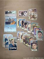 Photo showing 27 vintage 1950s non-sports trading cards laid out, featuring portraits of US Presidents, historical and famous people, and themed adventure cards.