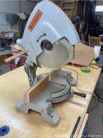 Full view of the Hitachi 15-inch miter saw, showing saw blade, base, and miter adjustment handle.