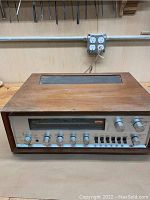Front view of Pioneer SX-1000TW stereo receiver showing wooden walnut finish, control knobs, switches, and tuning display.