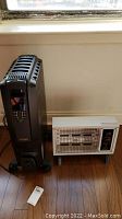 Photo showing both the Delonghi oil-filled heater and a smaller white heater side by side on the floor.