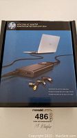 Front side of HP 65W Slim AC Adapter box showing product photo and branding.