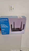 Front view of sealed box for Linksys Max-Stream Tri-Band Mesh WiFi 5 Router AC3000 showing model details and coverage capabilities.