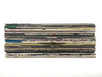 Stack of 12-inch vinyl LP records showing spines with artist names and titles